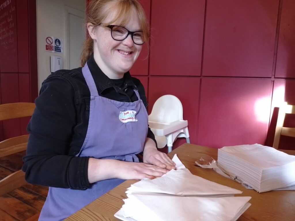 one former ema student working at a restaurant folding napkins