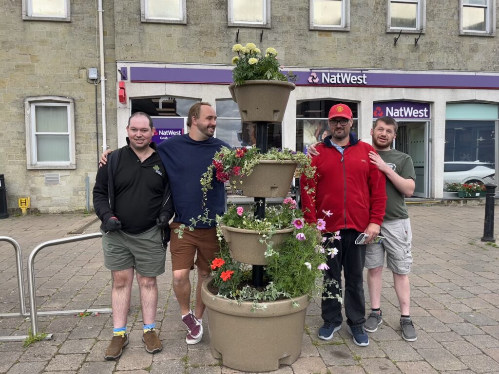 people are shown standing next to a tower of plants in a town