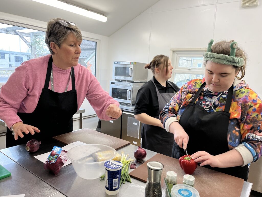 Students and a tutor working in the Kitchen at the EMA Gillingham Campus.